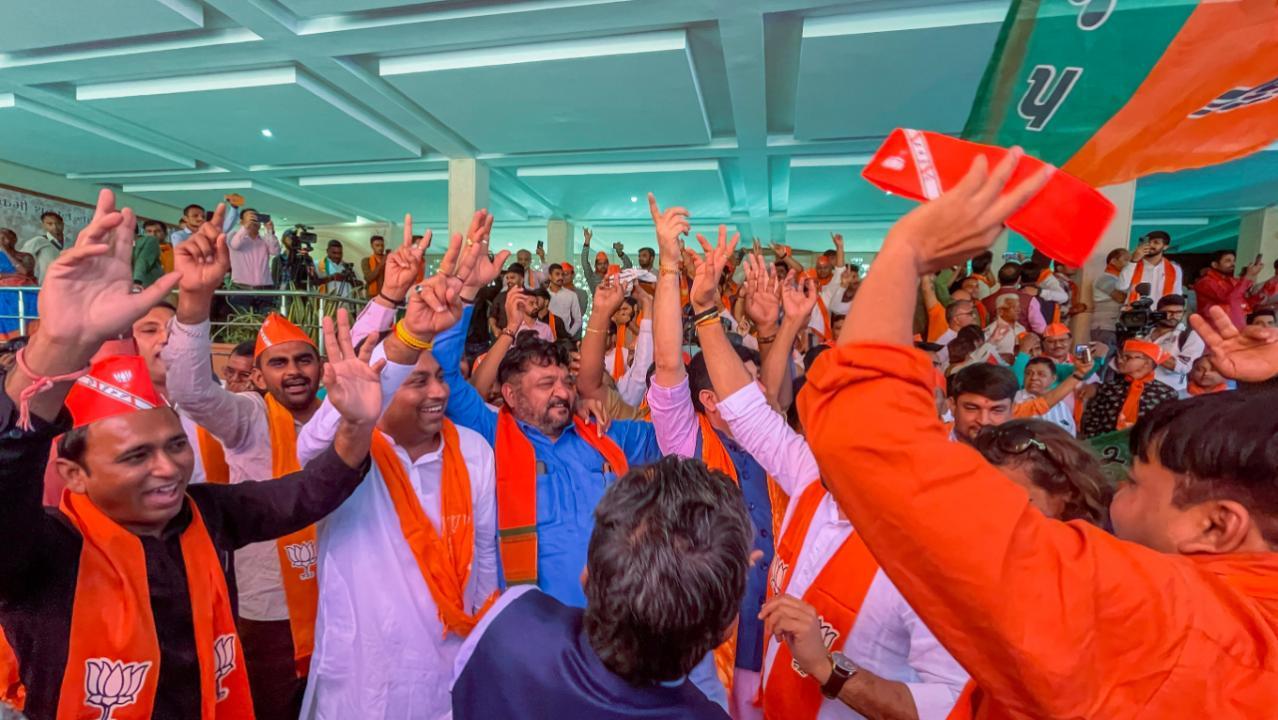 BJP leaders and workers dance as they celebrate the party's decisive lead in Gujarat Assembly elections, in Ahmedabad